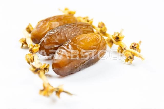 صورة مقرّبة لتمور جزائرية ملكية على خلفية بيضاء. مفهوم رمضان.
