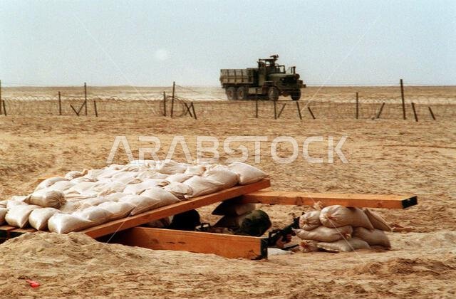 Seabees from Naval Mobile Construction Battalion 5 (NMCB-5) man a fighting position as an M-923 5-ton truck drives past during a camp defense drill. NMCB-5 is in northern Saudi Arabia to provide engineering support for coalition forces during Operation Desert Storm. Subject Operation/Series: DESERT STORM Country: Saudi Arabia (SAU)