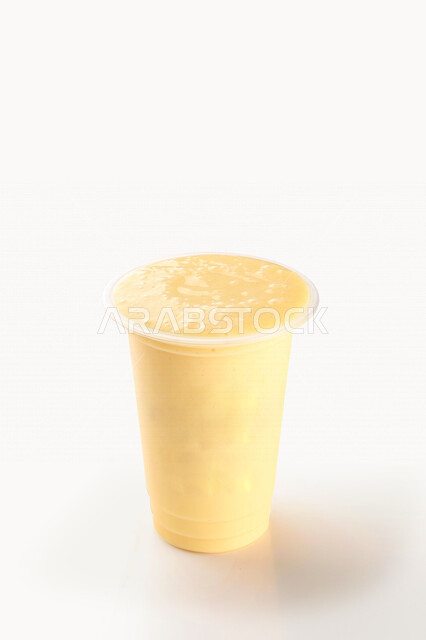 صورة مقربة لكوب من عصير الاصفهاني اللذيذ، مشروب بارد من فاكهة المانجا، مشروبات باردة، عصائر طبيعية لذيذة، عصير صحي ومفيد، كوكتيل صيفي منعش ومثلج، خلفية بيضاء