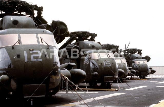 تم تأمين مروحيات CH-53 سي ستاليون على سطح سفينة الإنزال البرمائي يو إس إس إيو جيما (LPH-2) استعدادًا لنقلها إلى المملكة العربية السعودية لدعم عملية درع الصحراء. العملية/السلسلة: درع الصحراء. القاعدة: مورهيد سيتي. الولاية: كارولاينا الشمالية. الدولة: الولايات المتحدة الأمريكية.