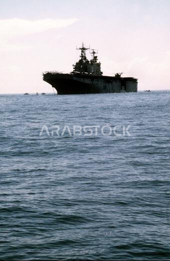 A CH-53 Sea Stallion helicopter lands aboard the amphibious assault ship USS NASSAU (LHA-4) as it lies at anchor offshore. The NASSAU will be transporting U.S. Marines and their equipment to Saudi Arabia in support of Operation Desert Shield. Subject Operation/Series: DESERT SHIELD State: North Carolina (NC) Country: United States Of America (USA)
