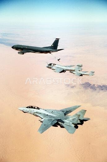 A Tactical Electronic Warfare Squadron 130 (VAQ-130) EA-6B Prowler aircraft refuels from a KC-135 Stratotanker aircraft as another Prowler and a Fighter Squadron 32 (VF-32) F-14A Tomcat aircraft fly in formation nearby. The aircraft are en route to targets over Iraq and Kuwait during Operation Desert Storm. Subject Operation/Series: DESERT STORM Country: Saudi Arabia (SAU)