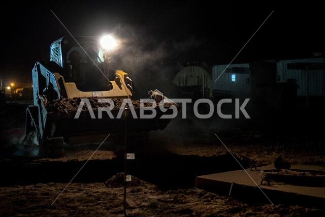 يقوم الجندي تراميل روبنسون، من سلاح الجو الأمريكي، وهو مشغل معدات ثقيلة تابع لسرب ريد هورس الاستكشافي 557، بتشغيل جرافة انزلاقية لردم قناة في قاعدة الأمير سلطان الجوية بالمملكة العربية السعودية، في 29 سبتمبر 2022. وبتوجيه من القيادة المركزية للقوات الجوية الأمريكية، يجب أن تدعم وحدات الإسكان الجديدة المعبأة في حاويات في قاعدة الأمير سلطان الجوية خدمة واي فاي كافية قبل أن يتمكن أفراد الخدمة من الانتقال إليها. وقد مثّل اليوم الأخير من ردم القناة لحظة تاريخية في تاريخ مجموعة المهندسين المدنيين الاس