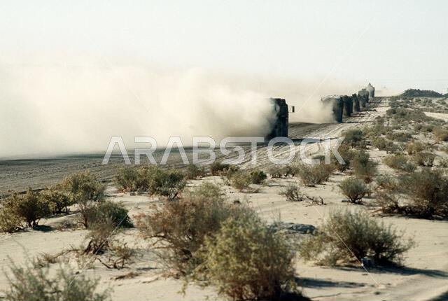 Dust envelopes a U.S. Army convoy on a desert road during Operation Desert Shield. Subject Operation/Series: DESERT SHIELD Country: Saudi Arabia(SAU)