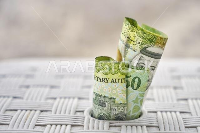 A closeup shot of green Saudi Arabia banknotes, wedged in a white surface, the concept of wealth and savings