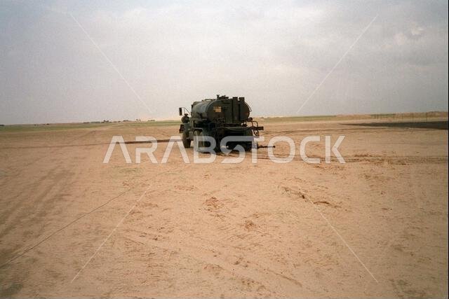 شاحنة من طراز M-809 تابعة لكتيبة الإنشاءات البحرية المتنقلة رقم 24 (NMCB-24)، حمولتها 5 أطنان، تتجه نحو مطار لونسم دوف الاستكشافي خلال عملية عاصفة الصحراء. الشاحنة مزودة بنظام تخزين ورش مواد البيتومين المستخدم في صيانة المطار. العملية/السلسلة: عاصفة الصحراء، الدولة: المملكة العربية السعودية.