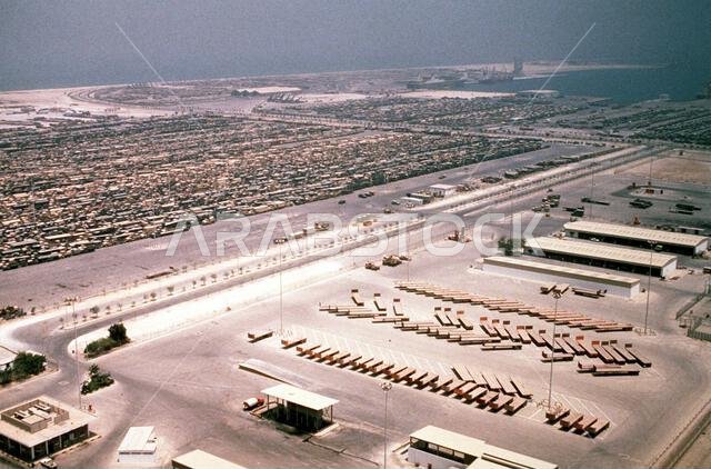 تصطف المعدات العسكرية في منطقة تجميع قرب ميناء الدمام استعداداً لنقلها إلى الولايات المتحدة في أعقاب عمليتي درع الصحراء وعاصفة الصحراء. العملية/السلسلة: درع الصحراء، عاصفة الصحراء. الدولة: المملكة العربية السعودية.