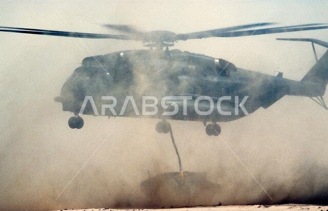 تقوم مروحية من طراز CH-53 Sea Stallion تابعة لقوات مشاة البحرية الأمريكية بإنزال مركبة M998 متعددة الأغراض ذات عجلات عالية الحركة (HMMWV) إلى الأرض خلال تمرين الرعد الوشيك، وهو جزء من عملية درع الصحراء. الموضوع: عملية/سلسلة: الرعد الوشيك - درع الصحراء. الدولة: المملكة العربية السعودية.