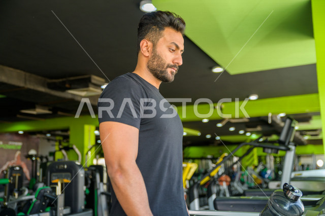 A young Saudi Arabian Gulf man is exercising on a treadmill, exercising in the gym