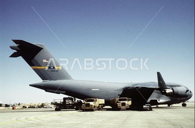 طائرة من طراز C-17A تابعة للسرب الرابع عشر للنقل الجوي، قاعدة تشارلستون الجوية، كارولاينا الجنوبية، تُفرغ حمولتها وتُزود بالوقود في مطار بالأردن استعدادًا لقوة التدخل الجوي القادمة التي ستُنفذ في الأردن. وتتمثل إحدى المهام الثانوية لهذه القوة في مساعدة القوات الجوية الأمريكية وقوات متعددة الجنسيات أخرى تعمل في المملكة العربية السعودية والدول المجاورة على تسيير دوريات في منطقة حظر الطيران فوق جنوب العراق. الموضوع: عملية/سلسلة: قوة التدخل الجوي