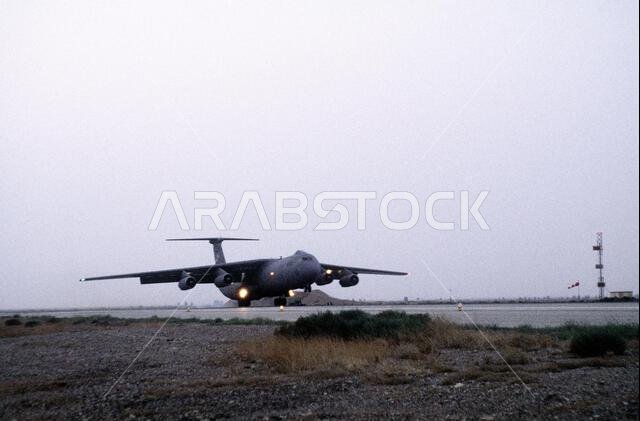 تهبط طائرة من طراز C-141B قادمة من قاعدة تشارلستون الجوية في ولاية كارولاينا الجنوبية في قاعدة الأزرق الجوية بالأردن. تحمل الطائرة أفرادًا ومؤنًا لقوة التدخل الجوي. ومن مهام هذه القوة مساعدة القوات الجوية الأمريكية وقوات متعددة الجنسيات أخرى تعمل في المملكة العربية السعودية ودول مجاورة في تسيير دوريات في منطقة حظر الطيران فوق جنوب العراق. الموضوع: عملية/سلسلة: قوة التدخل الجوي، القاعدة: قاعدة الأزرق الجوية، الدولة: الأردن (JOR). تهبط طائرة من طراز C-141B قادمة من قاعدة تشارلستون الجوية في ولاية كارولاينا الجنوبية في قاعدة الأزرق الجوية بالأردن. تحمل الطائرة أفرادًا ومؤنًا لقوة التدخل الجوي. ومن مهام هذه القوة مساعدة القوات الجوية الأمريكية وقوات متعددة الجنسيات أخرى تعمل في المملكة العربية السعودية ودول مجاورة في تسيير دوريات في منطقة حظر الطيران فوق جنوب العراق. الموضوع: عملية/سلسلة: قوة التدخل الجوي، القاعدة: قاعدة الأزرق الجوية، الدولة: الأردن (JOR).