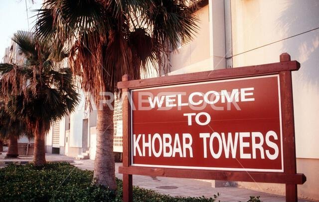 A sign marks the entrance of the Khobar Towers complex. The explosion of a fuel truck set off by terrorists at 2:55 p.m. EDT, Tuesday, June 25, 1996, outside the northern fence of the Khobar Towers complex near King Abdul Aziz Air Base, killed 19 and injured over 260. The facility housed U.S. service members and served as the headquarters for the 4404th Wing (Provisional), Southwest Asia. Subject Operation/Series: SOUTHERN WATCH Base: Dhahran Country: Saudi Arabia (SAU)