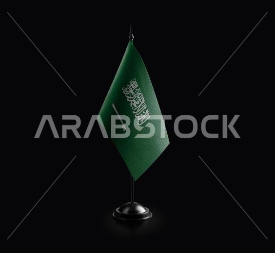 Small national flag of the Saudi Arabia on a black background.