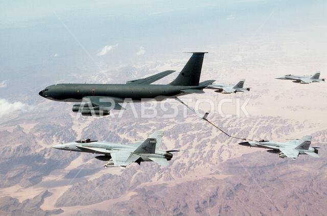 تقوم طائرة التزود بالوقود KC-135 ستراتوتانكر بتزويد طائرة مقاتلة من طراز F/A-18C هورنت تابعة لسرب المقاتلات الهجومية 81 (VFA-81) بالوقود، بينما تحلق طائرات هورنت أخرى من السرب في تشكيل جوي خلال عملية عاصفة الصحراء. الموضوع: عملية/سلسلة: عاصفة الصحراء، الدولة: المملكة العربية السعودية.