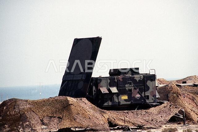 تم نشر رادار AN/MPQ-53 لنظام الدفاع الجوي التكتيكي MIM-104 باتريوت في موقع تم إنشاؤه حديثًا خلال عملية درع الصحراء. يُعدّ الرادار جهازًا متعدد الوظائف، يعمل بتقنية المصفوفة الطورية، ويؤدي وظائف المراقبة والتتبع والتوجيه. العملية/السلسلة: درع الصحراء، الدولة: المملكة العربية السعودية. تم نشر رادار AN/MPQ-53 لنظام الدفاع الجوي التكتيكي MIM-104 باتريوت في موقع تم إنشاؤه حديثًا خلال عملية درع الصحراء. يُعدّ الرادار جهازًا متعدد الوظائف، يعمل بتقنية المصفوفة الطورية، ويؤدي وظائف المراقبة والتتبع والتوجيه. العملية/السلسلة: درع الصحراء، الدولة: المملكة العربية السعودية.