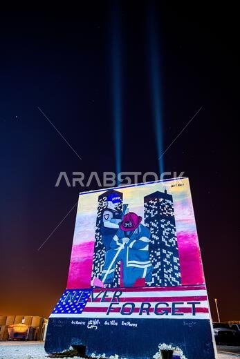 U.S. firefighters, assigned to the 378th Expeditionary Civil Engineer Squadron, lit beacons, Sept. 10, 2022, above a mural at Prince Sultan Air Base, Kingdom of Saudi Arabia, painted in honor of the victims and first responders who passed away on September 11, 2001. Since the events of 9/11, the U.S. has deployed hundreds of thousands to the outer limits of its American borders and to every corner of the globe to eradicate terrorism. 378th Air Expeditionary Wing,378th Expeditionary Civil Enginee