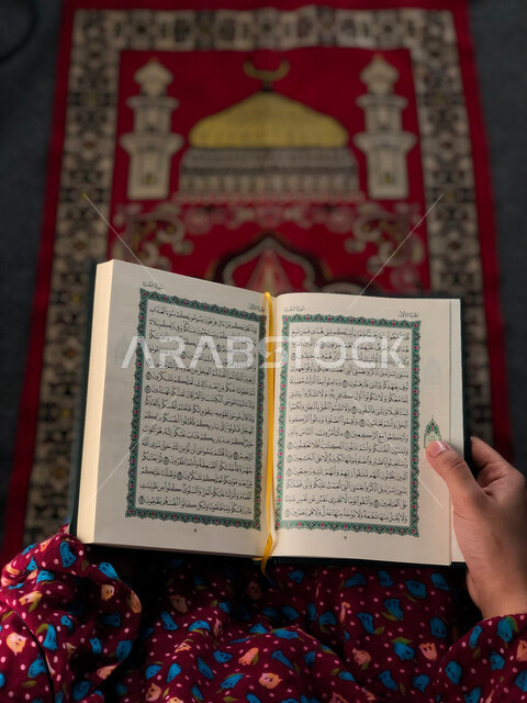 Gulf Arab girl wearing a prayer cap, performing prayers, worshiping and getting closer to God, reading and reciting the Qur’an, worshiping in the houses of God, remembrance of God, memorizing the Holy Qur’an, interpretation of the Qur’an