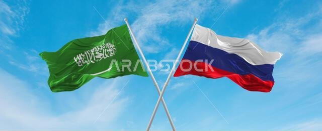 علمان متقاطعان، علم روسيا وعلم السعودية، يرفرفان في مهب الريح تحت سماء ملبدة بالغيوم. يرمز هذا العمل الفني إلى مفهوم العلاقة والحوار والسفر بين البلدين. رسم ثلاثي الأبعاد.