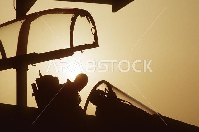 The pilot of a 1ST Tactical Fighter Squadron F-15C Eagle aircraft is silhouetted against the sun as he climbs into the cockpit of his aircraft during Operation Desert Shield. Subject Operation/Series: DESERT SHIELD Country: Saudi Arabia (SAU) The pilot of a 1ST Tactical Fighter Squadron F-15C Eagle aircraft is silhouetted against the sun as he climbs into the cockpit of his aircraft during Operation Desert Shield. Subject Operation/Series: DESERT SHIELD Country: Saudi Arabia (SAU)