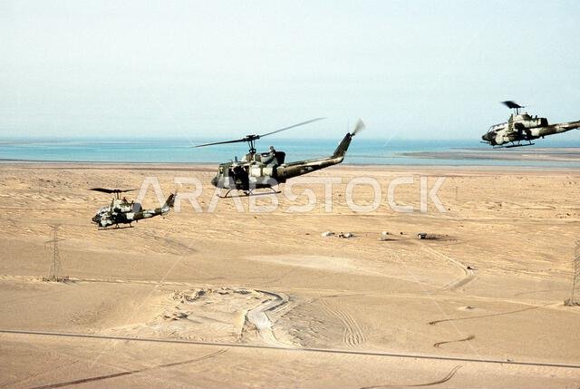 A Marine Corps UH-1N Iroquois helicopter, center, and two AH-1T Sea Cobra helicopters fly near Landing Zone 32 (LZ-32) Site Alpha during Operation Desert Shield. Subject Operation/Series: DESERT SHIELD Country: Saudi Arabia (SAU) A Marine Corps UH-1N Iroquois helicopter, center, and two AH-1T Sea Cobra helicopters fly near Landing Zone 32 (LZ-32) Site Alpha during Operation Desert Shield. Subject Operation/Series: DESERT SHIELD Country: Saudi Arabia (SAU)