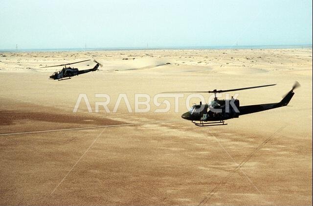 A UH-1N Iroquois helicopter, foreground, and an AH-1 Sea Cobra helicopter fly over the desert during Operation Desert Shield. Subject Operation/Series: DESERT SHIELD Country: Saudi Arabia (SAU) A UH-1N Iroquois helicopter, foreground, and an AH-1 Sea Cobra helicopter fly over the desert during Operation Desert Shield. Subject Operation/Series: DESERT SHIELD Country: Saudi Arabia (SAU)