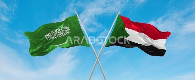 علمان متقاطعان، علم السودان وعلم السعودية، يرفرفان في مهب الريح تحت سماء ملبدة بالغيوم. يرمز هذا العمل الفني إلى مفهوم العلاقة والحوار والسفر بين البلدين. رسم ثلاثي الأبعاد.