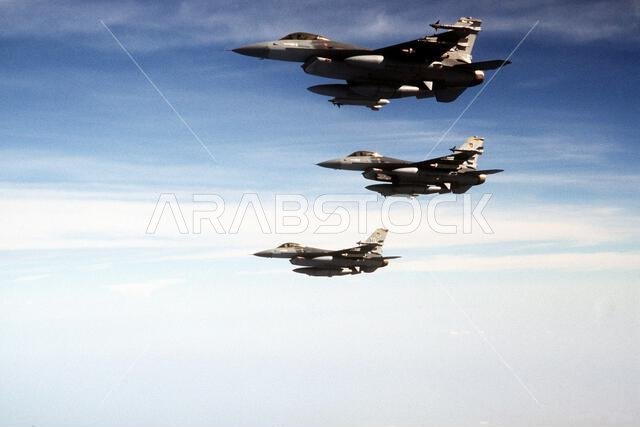 An air-to-air view of three F-16C Fighting Falcon aircraft of the 388th Tactical Fighter Wing en route to Saudi Arabia for Operation Desert Shield. Each aircraft is carrying external fuel tanks, AIM-9 Sidewinder missiles and an AN/ALQ-131 electronic countermeasures (ECM) pod. The center aircraft is also carrying a low altitude navigation, targeting infrared night (LANTIRN) navigation pod on the left side of its engine intake. Subject Operation/Series: DESERT SHIELD Country: Unknown An air-to-air view of three F-16C Fighting Falcon aircraft of the 388th Tactical Fighter Wing en route to Saudi Arabia for Operation Desert Shield. Each aircraft is carrying external fuel tanks, AIM-9 Sidewinder missiles and an AN/ALQ-131 electronic countermeasures (ECM) pod. The center aircraft is also carrying a low altitude navigation, targeting infrared night (LANTIRN) navigation pod on the left side of its engine intake. Subject Operation/Series: DESERT SHIELD Country: Unknown