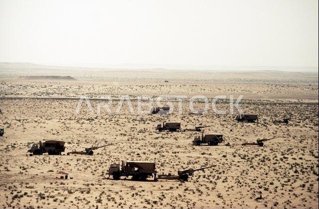 مركبات شتاير تقف بالقرب من مدافع هاوتزر FH-70 عيار 155 ملم بعد نقلها إلى موقع دفاعي خلال عملية درع الصحراء. العملية/السلسلة: درع الصحراء. الدولة: المملكة العربية السعودية. مركبات شتاير تقف بالقرب من مدافع هاوتزر FH-70 عيار 155 ملم بعد نقلها إلى موقع دفاعي خلال عملية درع الصحراء. العملية/السلسلة: درع الصحراء. الدولة: المملكة العربية السعودية.