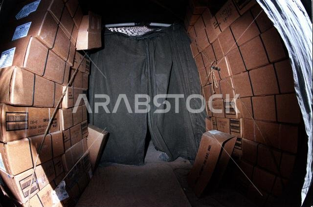 Cases of meals, ready-to-eat (MREs) fill the entrance to the G-3 tent at the 2nd Marine Division combat operations center during Operation Desert Storm. Subject Operation/Series: DESERT STORM Country: Saudi Arabia (SAU)