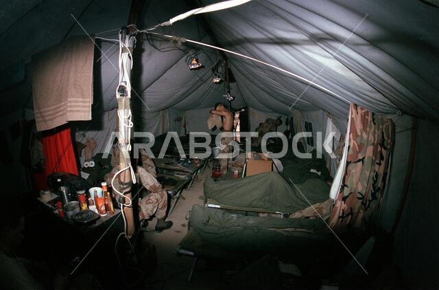 Enlisted G-3 personnel relax in their tent at the 2nd Marine Division combat operations center during Operation Desert Storm. Subject Operation/Series: DESERT STORM Country: Saudi Arabia (SAU)
