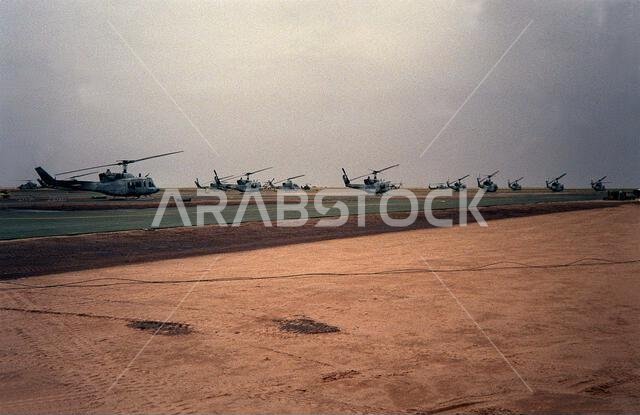 صورة لمروحيات من طراز UH-1N إيروكوا و AH-1 كوبرا متوقفة على مدرج مطار لونسم دوف الاستكشافي خلال عملية عاصفة الصحراء. الموضوع: عملية/سلسلة: عاصفة الصحراء. الدولة: المملكة العربية السعودية. صورة لمروحيات من طراز UH-1N إيروكوا و AH-1 كوبرا متوقفة على مدرج مطار لونسم دوف الاستكشافي خلال عملية عاصفة الصحراء. الموضوع: عملية/سلسلة: عاصفة الصحراء. الدولة: المملكة العربية السعودية.