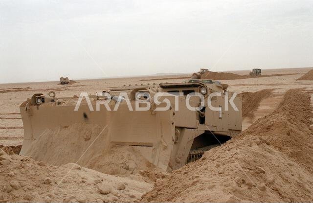جندي من مشاة البحرية من الكتيبة الثانية للهندسة القتالية، الفرقة الثانية لمشاة البحرية، يُشغّل جرافة قتالية مدرعة من طراز M-9 (ACE) أثناء تجهيز المواقع لفرقة العمل "بريتش ألفا" على التل 231 خلال عملية عاصفة الصحراء. الموضوع: عاصفة الصحراء، الدولة: المملكة العربية السعودية. جندي من مشاة البحرية من الكتيبة الثانية للهندسة القتالية، الفرقة الثانية لمشاة البحرية، يُشغّل جرافة قتالية مدرعة من طراز M-9 (ACE) أثناء تجهيز المواقع لفرقة العمل "بريتش ألفا" على التل 231 خلال عملية عاصفة الصحراء. الموضوع: عاصفة الصحراء، الدولة: المملكة العربية السعودية.