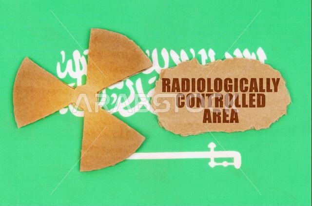 مفهوم الصناعة والإشعاع. على علم المملكة العربية السعودية، رمز النشاط الإشعاعي وقطعة من الورق المقوى الممزق مكتوب عليها "إشعاعي". مفهوم الصناعة والإشعاع. على علم المملكة العربية السعودية، رمز النشاط الإشعاعي وقطعة من الورق المقوى الممزق مكتوب عليها "إشعاعي".