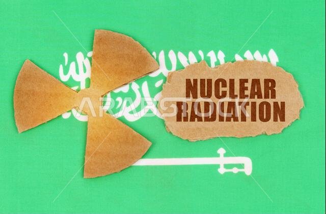 مفهوم الصناعة والإشعاع. على علم المملكة العربية السعودية، رمز النشاط الإشعاعي وقطعة من الورق المقوى الممزق مكتوب عليها "الإشعاع النووي". مفهوم الصناعة والإشعاع. على علم المملكة العربية السعودية، رمز النشاط الإشعاعي وقطعة من الورق المقوى الممزق مكتوب عليها "الإشعاع النووي".