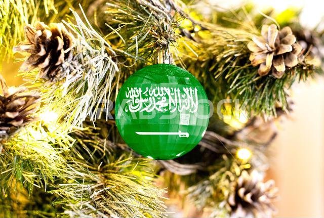 New Year's glass ball with the flag of Saudi Arabia against a colorful Christmas background