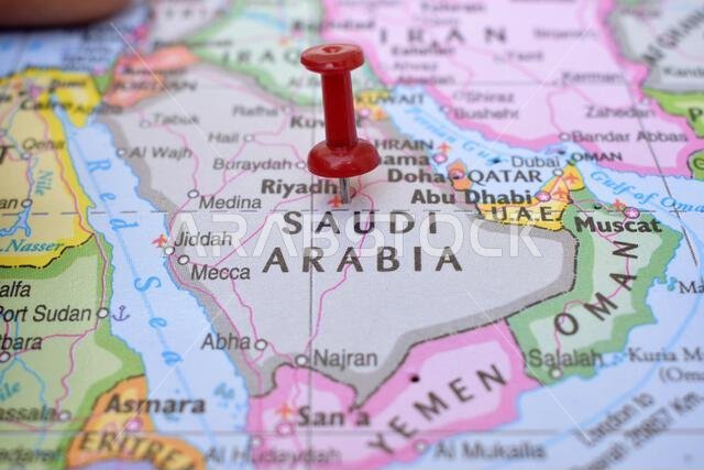 Red Push Pin Pointing on Location of Saudi Arabia World Map Close-Up View Stock Photograph