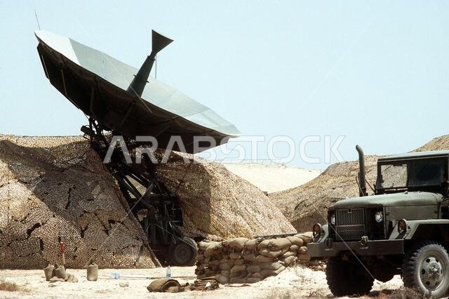 شاحنة نقل بضائع من طراز M-54 سعة 5 أطنان متوقفة بالقرب من هوائي في موقع اتصالات خلال عملية درع الصحراء. العملية/السلسلة: درع الصحراء. الدولة: المملكة العربية السعودية. شاحنة نقل بضائع من طراز M-54 سعة 5 أطنان متوقفة بالقرب من هوائي في موقع اتصالات خلال عملية درع الصحراء. العملية/السلسلة: درع الصحراء. الدولة: المملكة العربية السعودية.