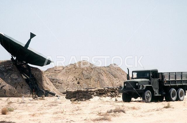 شاحنة نقل بضائع من طراز M-54 سعة 5 أطنان متوقفة بالقرب من هوائي في موقع اتصالات خلال عملية درع الصحراء. العملية/السلسلة: درع الصحراء. الدولة: المملكة العربية السعودية. شاحنة نقل بضائع من طراز M-54 سعة 5 أطنان متوقفة بالقرب من هوائي في موقع اتصالات خلال عملية درع الصحراء. العملية/السلسلة: درع الصحراء. الدولة: المملكة العربية السعودية.