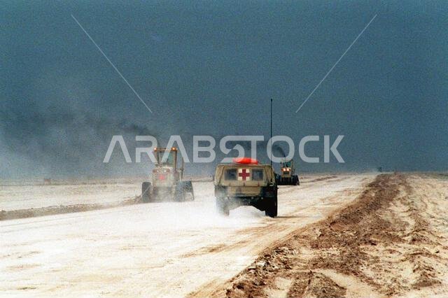 An M1035 High-Mobility Multipurpose Wheeled Vehicle (HMMWV) ambulance drives toward two Naval Mobile Construction Battalion 5 (NMCB-5) motor graders performing maintenance on a road in northern Saudi Arabia during Operation Desert Storm. Subject Operation/Series: DESERT STORM Country: Saudi Arabia (SAU) An M1035 High-Mobility Multipurpose Wheeled Vehicle (HMMWV) ambulance drives toward two Naval Mobile Construction Battalion 5 (NMCB-5) motor graders performing maintenance on a road in northern Saudi Arabia during Operation Desert Storm. Subject Operation/Series: DESERT STORM Country: Saudi Arabia (SAU)