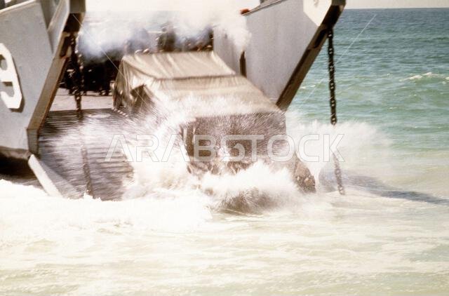 A U.S. Marine Corps M-998 high-mobility multipurpose wheeled vehicle plunges into the surf after being delivered to the beach as part of an amphibious exercise during Operation Desert Shield. Subject Operation/Series: DESERT SHIELD Country: Saudi Arabia (SAU)