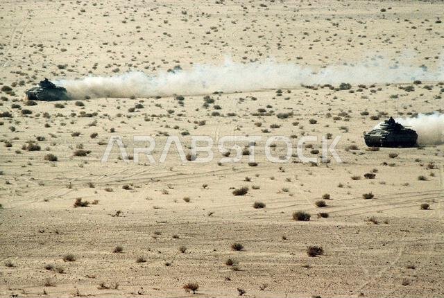 Two M-2 Bradley infantry fighting vehicles maneuver in the desert during a U.S. and Saudi live-fire exercise during Operation Desert Shield. Subject Operation/Series: DESERT SHIELD Country: Saudi Arabia(SAU)