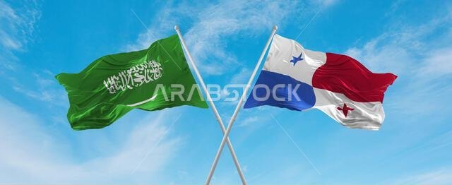 علمان متقاطعان، علم بنما وعلم السعودية، يرفرفان في مهب الريح تحت سماء ملبدة بالغيوم. يرمزان إلى مفهوم العلاقة والحوار والسفر بين البلدين. رسم توضيحي ثلاثي الأبعاد