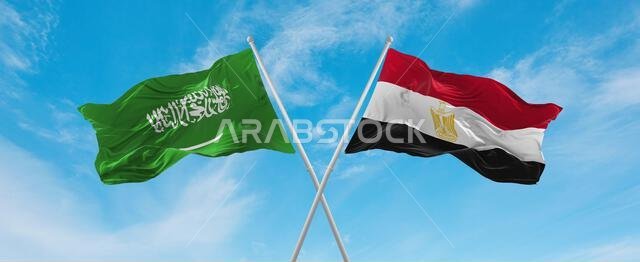 علمان متقاطعان، علم مصر وعلم السعودية، يرفرفان في مهب الريح تحت سماء ملبدة بالغيوم. يرمز هذا العمل الفني إلى مفهوم العلاقة والحوار والسفر بين البلدين. رسم ثلاثي الأبعاد.