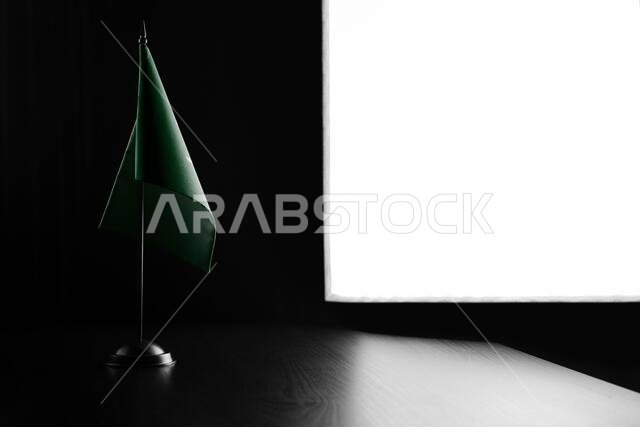 Small national flag of the Saudi Arabia on a black background.