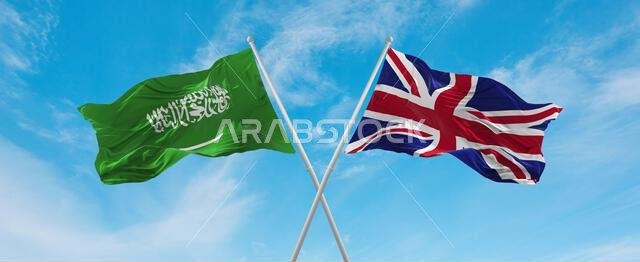 علمان متقاطعان، بريطانيا العظمى والمملكة العربية السعودية، يرفرفان في مهب الريح تحت سماء ملبدة بالغيوم. يرمزان إلى مفهوم العلاقة والحوار والسفر بين البلدين. ثلاثي الأبعاد