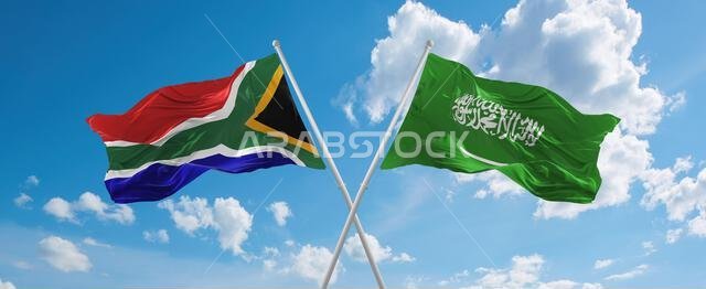 two crossed flags Saudi Arabia and South Africa waving in wind at cloudy sky. Concept of relationship, dialog, travelling between two countries. 3d il