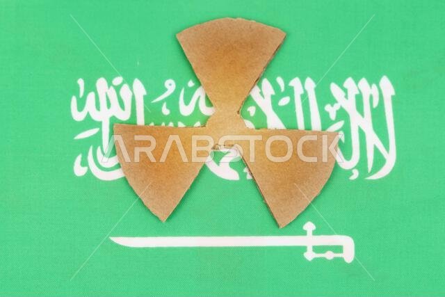 مفهوم الصناعة والإشعاع. علم المملكة العربية السعودية يحمل رمزاً للإشعاع.