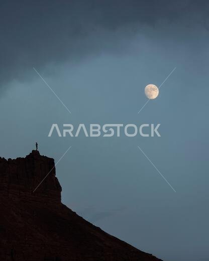 الوقوف على حافة الجبل أثناء مشاهدة القمر، منظر طبيعي خلاب من الحجر الرملي، يُعد تراثًا ثقافيًا وطبيعيًا استثنائيًا