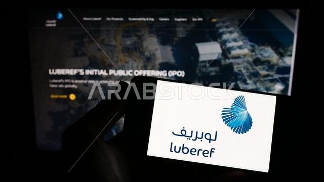 شخص يحمل هاتفًا ذكيًا عليه شعار شركة لوبريف السعودية للزيوت الأساسية معروضًا على الشاشة أمام موقع إلكتروني. التركيز على شاشة الهاتف. شخص يحمل هاتفًا ذكيًا عليه شعار شركة لوبريف السعودية للزيوت الأساسية معروضًا على الشاشة أمام موقع إلكتروني. التركيز على شاشة الهاتف.