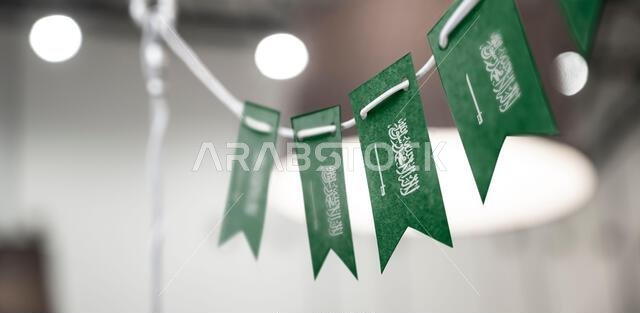إكليل من أعلام المملكة العربية السعودية على خلفية ضبابية مجردة.